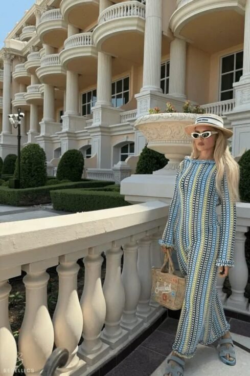 Elegant woman in a patterned 'Berna' maxi dress stands near a grand building, showcasing a timeless and versatile style.