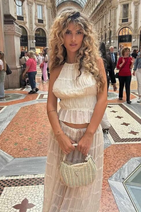 Boho Breeze summer outfit with ruffled details, halter top, and long skirt in a stylish urban setting.