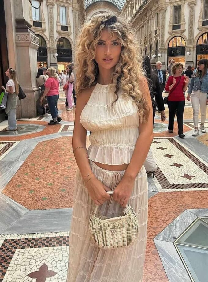 Boho Breeze summer outfit with ruffled details, halter top, and long skirt in a stylish urban setting.