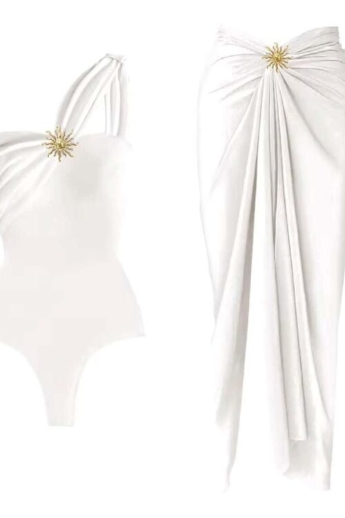 Elegance Beach Set with asymmetrical swimsuit and wrap skirt, featuring gold embellishment for a glamorous look.