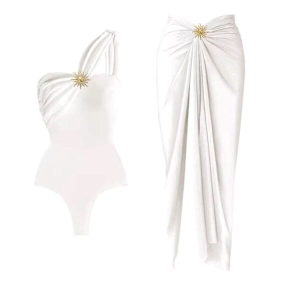 Elegance Beach Set with asymmetrical swimsuit and wrap skirt, featuring gold embellishment for a glamorous look.