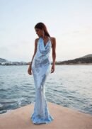 Luminous sequin gown in shimmering light-reflecting blue by the seaside.