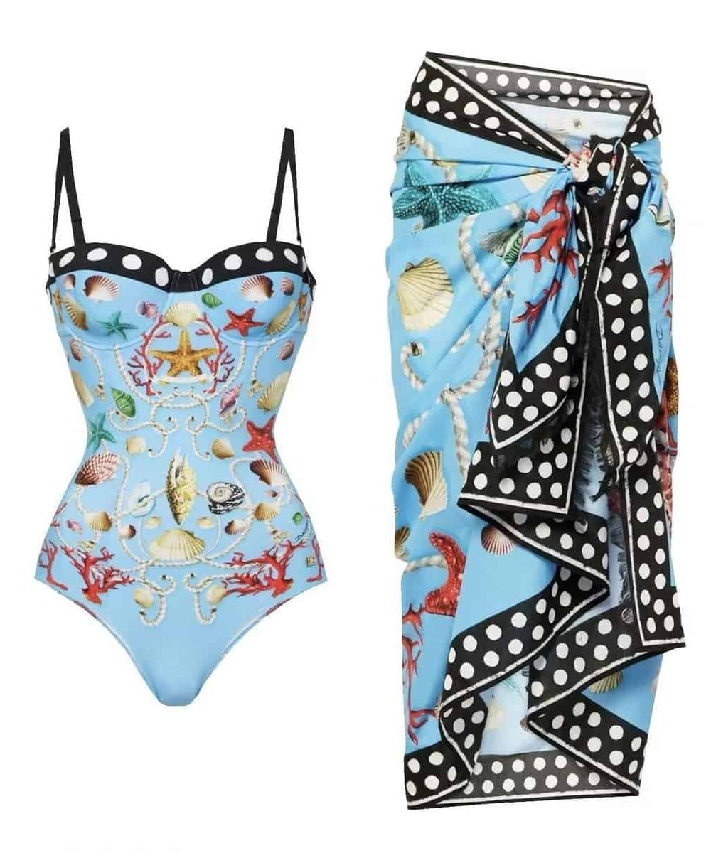 Luxurious 'Maritime Elegance' swim set featuring a shell and coral print swimsuit with a polka-dot trim sarong, in light blue.