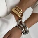 Serpent Armreifen in 925 Sterling Silber und 18K vergoldet, elegant am Handgelenk getragen.